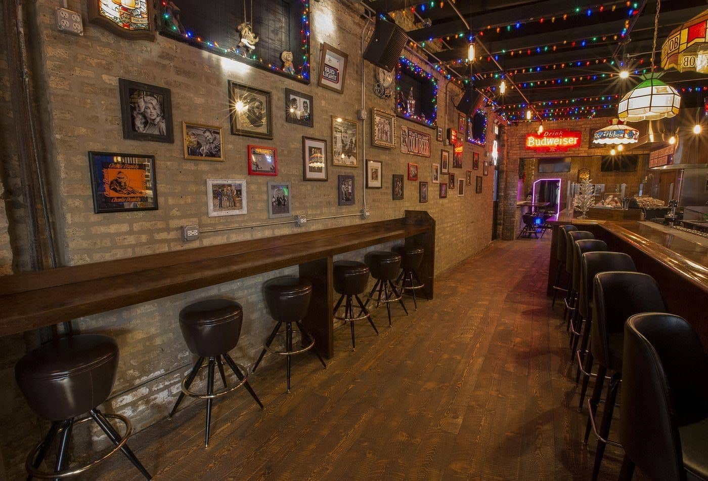 Brick wall, photos, and bar view inside Carol's Pub 